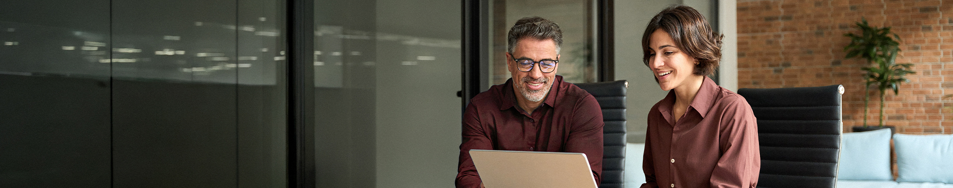 Mann und Frau schauen auf Laptop